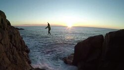 Man traverses highline stretched above sea below Stock Footage