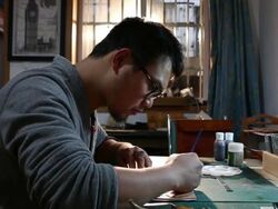 leatherworker paint fish pattern on leather Stock Footage