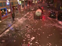 Medium Shot High Angle - Worker sprays trash filled street with hose / New Orleans Louisiana Stock Footage