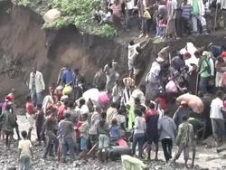 People climbing river bank after crossing river following bridge collapse Stock Footage