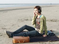 WS Woman sitting on beach listening to headphones / Isle of Palms, South Carolina, USA Stock Footage