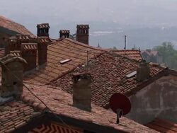 High Angle pan-right zoom-out - Buildings on a Varese hilltop have red tile roofs. / Varese, Italy Stock Footage