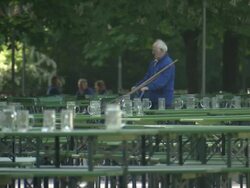 Englischer Garten - Chinesischer Turm, Biergarten, man cleans up, empty benches and tables, many jars Stock Footage
