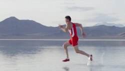MS PAN Athlete sprinting across surface of lake Stock Footage