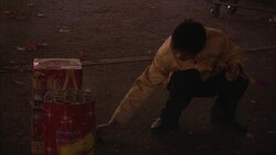 A man lights a firecracker during a Chinese New Year celebration. Stock Footage