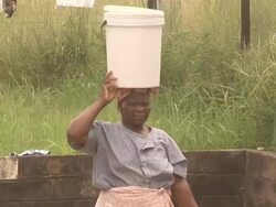 African lady using head to carry 2- HD & PAL Stock Footage