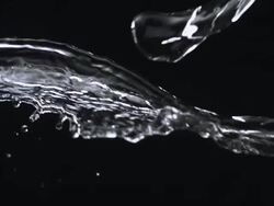CU SLO MO Shot of two sources of water from left and right crash together mid frame against black / United Kingdom Stock Footage