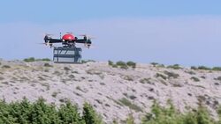 SLO MO UAV transporting a box across wild terrain Stock Footage