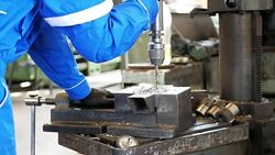 Worker in protective suit working in factory on machinery Stock Footage