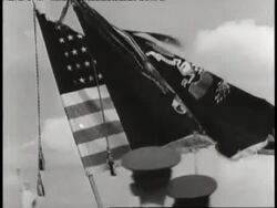 Soldiers watch an American flag and another flag pass by, with the Statue of Liberty in the distance. News Clip