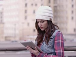 Wide view of woman in hat using tablet outside. Stock Footage