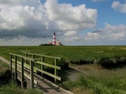 EWS View from green grass field of Westerhever lighthouse / Westerhever, Schleswig Holstein, Germany Stock Footage