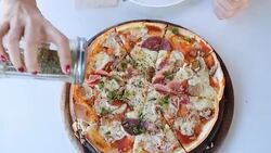 Woman put oregano on Pizza Stock Footage