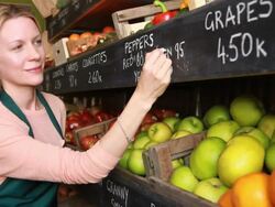 Female employee writing prices on board in Grocery shop Stock Footage