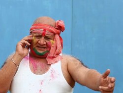 Senior man talking on a mobile phone in a holi festival  Stock Footage