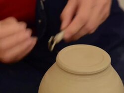 CU Shot of female potter finishing  bottom of pitch on potterwheel at pottery / Landshut, Bavaria, Germany Stock Footage