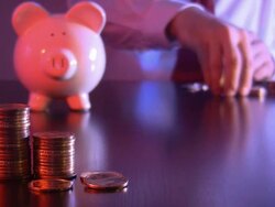 Businessman counting coins from a pile of change. Piggy bank. Stock Footage
