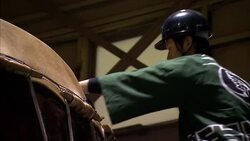 A drum maker hammers the edges of a huge taiko drum. Stock Footage