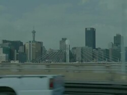 POV shot from a moving vehicle traveling on the highway passing Johannesburg CBD skyscrapers and the Nelson Mandela Bridge Stock Footage
