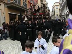 Parade of young people with Costaleros bearing a Trono a religious float during Semana Santa, a procession through the streets of Malaga, Spain, Europe Stock Footage