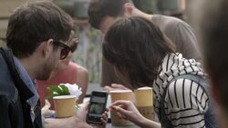 Young couple at outdoor caf_ scroll through photos on Instagram Stock Footage