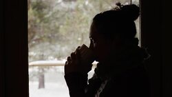 Beautiful young ethnic girl relaxing and drinking coffee looking out window Stock Footage