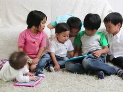 Children and baby using two tablet together sitting in living room Stock Footage