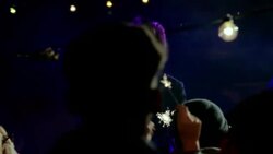 Wide dolly shot of lead guitar through party crowd with sparklers Stock Footage