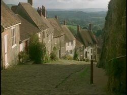 MS high angle, Gold Hill, Shaftesbury, Dorset - Cobbled street with row of cottages/homes Stock Footage