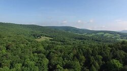4K aerial footage rising above the trees in the Catskills, in upstate New York. 3840 X 2160. Sunny day. Stock Footage