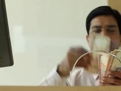 Bank Teller counting money at bank counter, Delhi, India Stock Footage