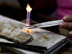 Goldsmith Jeweler use gasoline burner melting and decorating gold Stock Footage