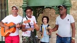 Cuba Tourism: Busking Musicians Sing Along a Tourist Child Stock Footage