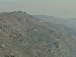 2010 AERIAL Gliders flying in the haze over barren, rocky mountains / Santiago de Chile, Gran Santiago, Chile Stock Footage