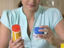 Young woman looking at vitamin pills Stock Footage