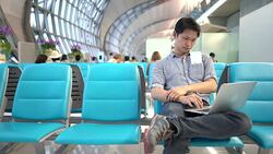 Young Man using laptop at airport, Using Laptop Stock Footage