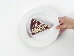 CU Woman hand entering setting down round white plate with slice of chocolate cheesecake, with white chocolate chips dessert / Omaha, Nebraska, United States Stock Footage