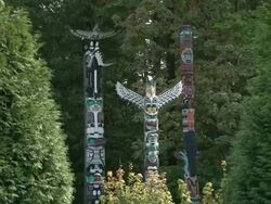 WS ZI View of 3 totem poles and bird shaped totem pole in the middle in stanley park / Vancouver, British Columbia, Canada Stock Footage