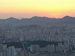 WS T/L Cityscape of Seoul at sun setting with hills in distance / Seoul, South Korea Stock Footage