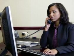 Bank manager using computer and answering telephone Stock Footage