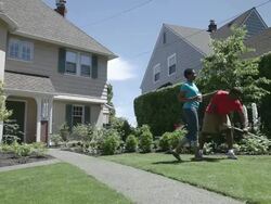  WS Man rking in garden woman emerges from house and hands him beverage  / Portland, Oregon, United States  Stock Footage