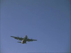 Lockheed c130 transport plane comes in to land overhead MS, blue sky, England, UK Stock Footage