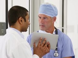 MS Doctor and Sugreon Discussing Patient Records on Tablet Computer / Richmond, Virginia, USA Stock Footage