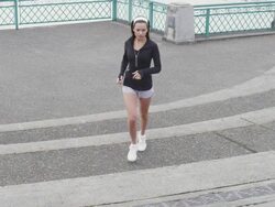 MS SLO MO Shot of young female jogger runs up concrete steps on city water front and looking into / Portland, Oregon, United States  Stock Footage