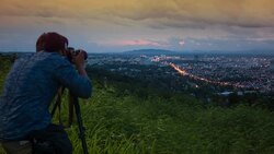 HD DOLLY : Nature photographer working on the mountain peak with camera and tripod Stock Footage