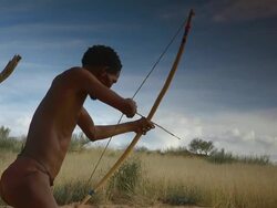 MS LA Shot of Bushman taking aim with bow and arrow, Boesmanland / North West Province, South Africa Stock Footage