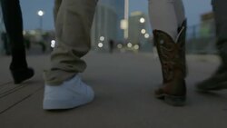 Group of friends walk across Pfluger Pedestrian Bridge towards downtown Austin, Texas Stock Footage