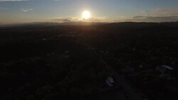 4K aerial video flying away from the sunset with clouds Stock Footage