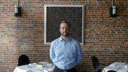 Proud restaurant owner stands at attention and smiles at camera Stock Footage