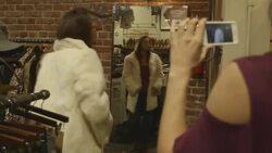 friends looking at smart phone and filming friends while they try on clothes and pose Stock Footage